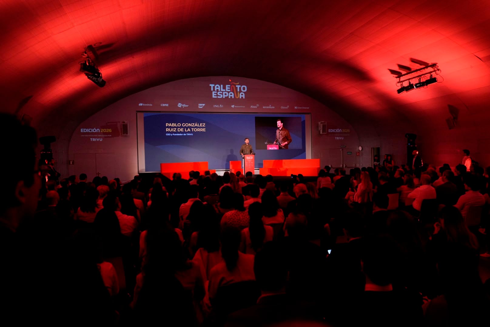 Edición 2026 de TALEÑTO España — la sala abovedada teñida de rojo